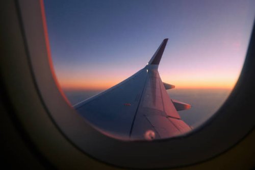view through airplane window during flight at sunset - travel stock pictures, royalty-free photos & images