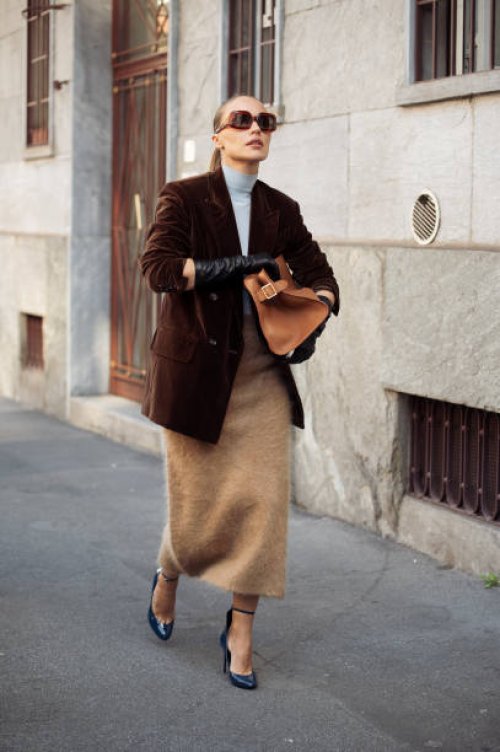 Viky Rader wears dark brown sunglasses, light blue turtle neck, dark brown velvet blazer jacket, light brown fluffy midi skirt, brown leather bag,...
