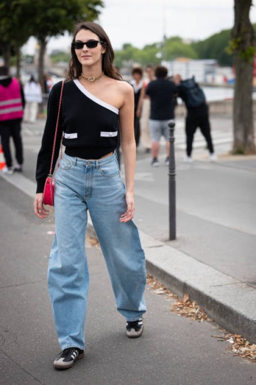 Vittoria Ceretti wears a black one sleeve top with white details, blue jeans, Adidas sneakers, black sunglasses, gold Chanel necklace and pink Chanel...