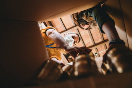 volunteers are preparing a donation box with nonperishable food - view from inside the cardboard box - food stock pictures, royalty-free photos & images