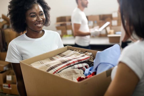 volunteers carrying clothing - home decoration stock pictures, royalty-free photos & images