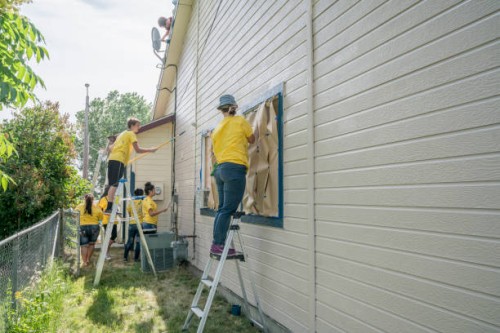 volunteers on ladders painting house - home decoration stock pictures, royalty-free photos & images