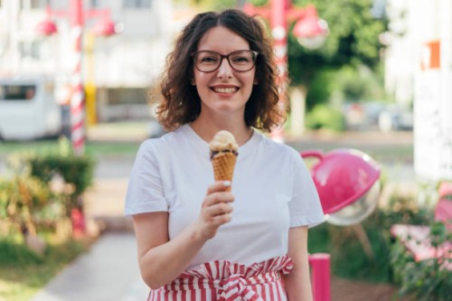 vrouw eten van ijs - junk food stockfoto's en -beelden