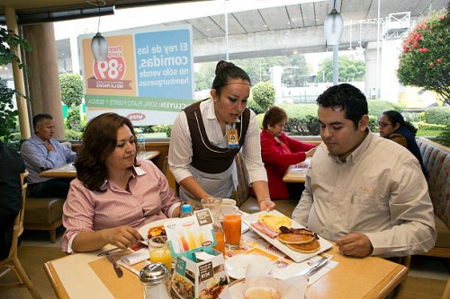 Waitress serves breakfast to customers at a Vips restaurant in the El Toreo neighborhood of Mexico City, Mexico, on Monday, June 17, 2013. Wal-Mart...