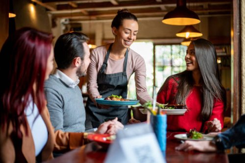 waitress serving food to a group of customers at a restaurant - food stock pictures, royalty-free photos & images