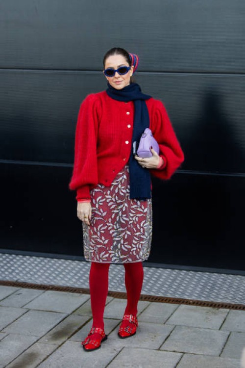 Wears navy scarf, red cardigan, transparent skirt with floral, red tights, purple bag outside Munthe during the Copenhagen Fashion Week AW24 on...