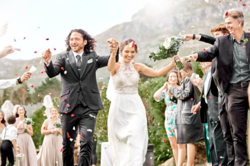 wedding, confetti and celebration with bride and groom celebrating, just married with friends and family at scenic venue. happy, fun and rose petals with couple celebrating success marriage ceremony - garden decoration stock 
