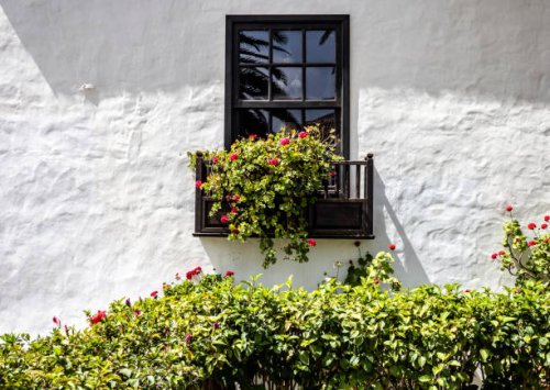 white facade with a wooden balcony adorned with flower pots. - garden decoration stock pictures, royalty-free photos & images