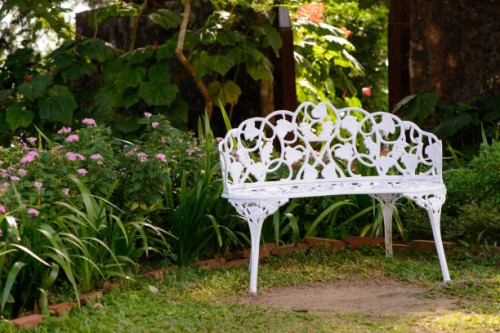 white metal bench in tropical garden - garden decoration stock pictures, royalty-free photos & images