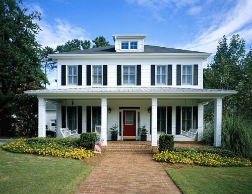 white wooden house, flowers blooming around front porch - garden decoration photos et images de collection