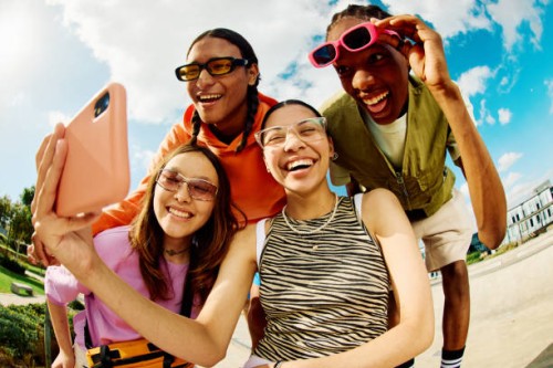 wide angle shot of gen z group of friends using a smartphone together. - fashion stock pictures, royalty-free photos & images