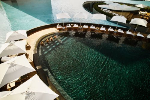 wide shot aerial view of family relaxing in pool at tropical resort - travel stock pictures, royalty-free photos & images