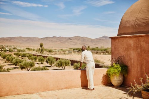 wide shot man enjoying view from rooftop terrace of luxury resort - travel stock pictures, royalty-free photos & images