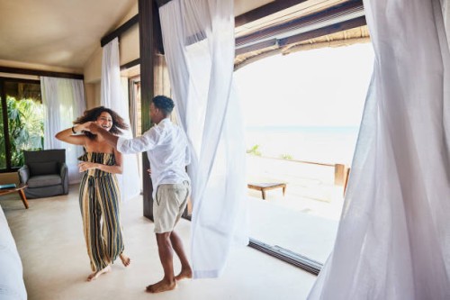 wide shot of couple dancing in luxury suite of tropical resort - travel stock pictures, royalty-free photos & images