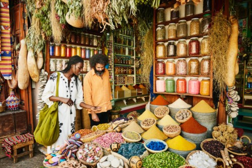 wide shot of couple shopping in spice shop in the souks of marrakech - food stock pictures, royalty-free photos & images