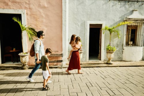 wide shot of family walking down street while exploring town during vacation - travel stock-fotos und bilder