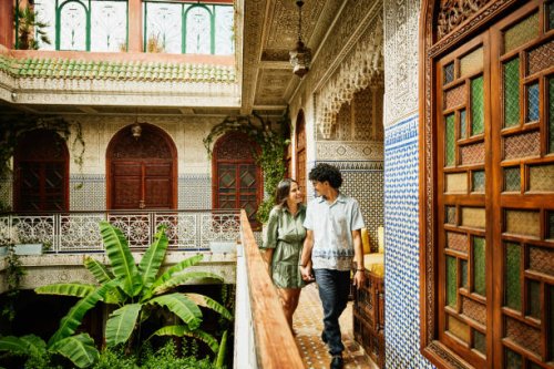 wide shot of smiling couple holding hands and walking through riad - travel stock pictures, royalty-free photos & images