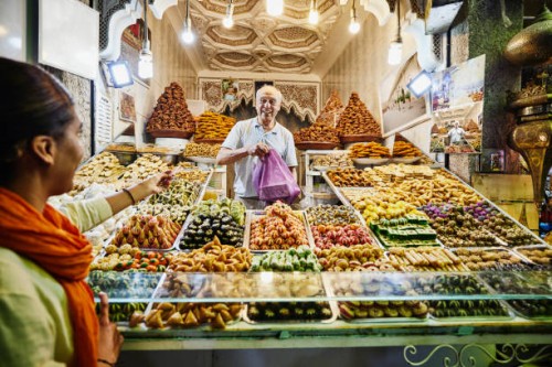 wide shot of smiling pastry shop owner taking payment from customer - food stock pictures, royalty-free photos & images