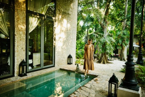 wide shot of smiling woman standing pool and putting foot in water at luxury tropical spa - travel stock pictures, royalty-free photos & images