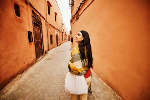 wide shot of woman exploring the medina of marrakech while on vacation - travel stock pictures, royalty-free photos & images