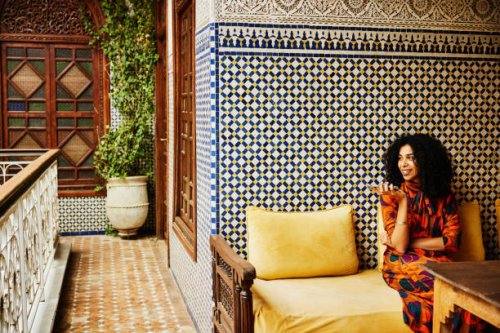 wide shot smiling woman relaxing in alcove of ornately decorated riad - travel stock pictures, royalty-free photos & images