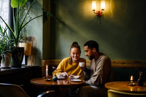 wide shot with copy space of couple sharing a dessert in cafe - coffee stockfoto's en -beelden