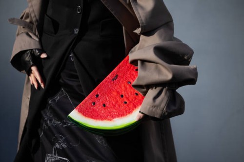 Willabelle On wears skirt with graphic print, red melon bag, cut out grey trench coat outside Moschino during the Milan Fashion Week Womenswear...