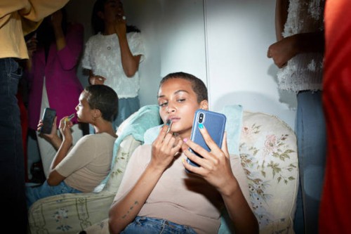 woman applying lipstick while looking in smart phone - fashion stock pictures, royalty-free photos & images