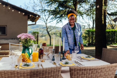 woman arranging table for outdoors gathering - garden decoration stock pictures, royalty-free photos & images