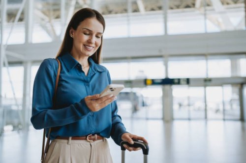 woman at the airport holding smartphone - travel stock pictures, royalty-free photos & images