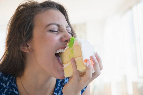 woman biting piece of cake - junk food stock pictures, royalty-free photos & images