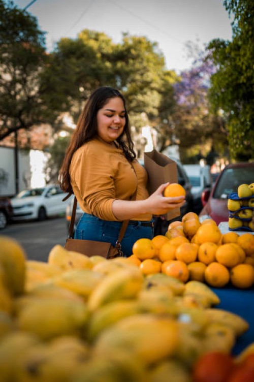 woman buying orange at the local market - food stock pictures, royalty-free photos & images