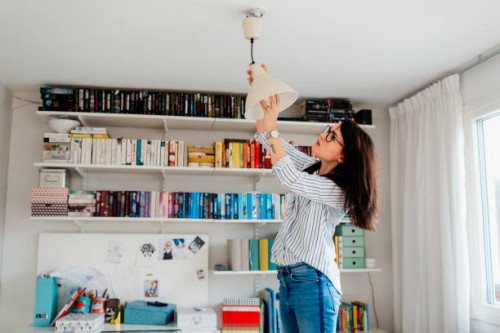 woman changing bulb in house - home decoration stock pictures, royalty-free photos & images