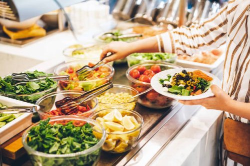 woman choosing food for breakfast at hotel restaurant. woman taking food from a buffet line. - food stock pictures, royalty-free photos & images