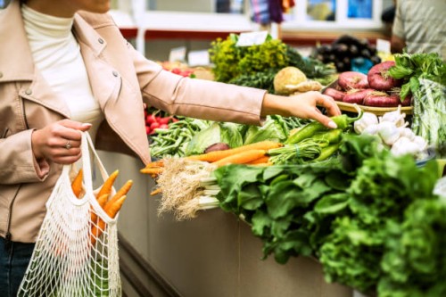 woman choosing greenery and vegetables at farmer market and using reusable eco bag. - food stock pictures, royalty-free photos & images