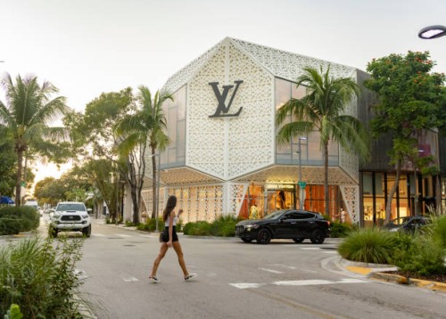 woman crossing the street by louis vuitton store in miami design district - fashion stock pictures, royalty-free photos & images