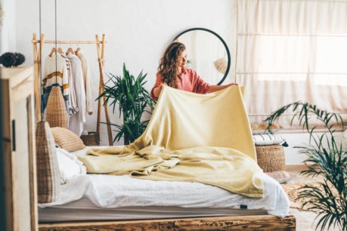 woman doing her morning routine, arranging pillows and making up bed at home. - home decoration stock pictures, royalty-free photos & images