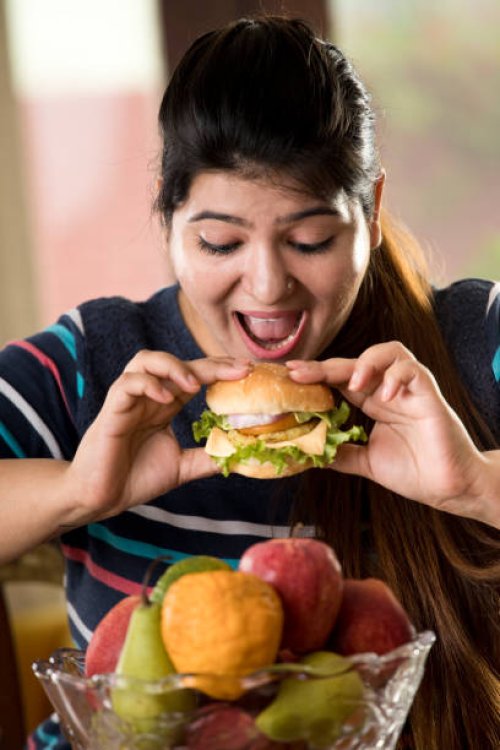 woman eating a fast food burger - junk food stock pictures, royalty-free photos & images