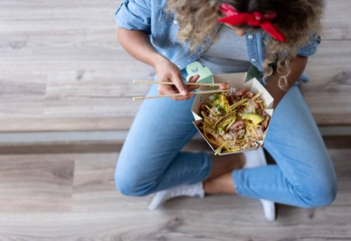 woman eating a poke bowl at home while moving house - junk food stock pictures, royalty-free photos & images