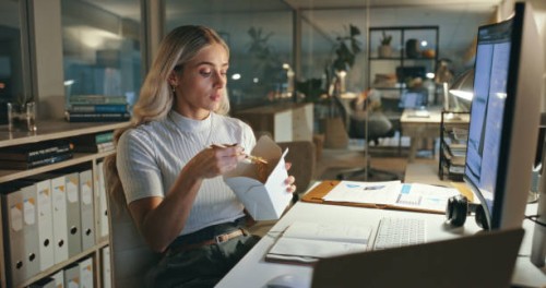 woman, eating and chinese food in office at night, working or employee reading computer, research and planning project. person, thinking and hungry for asian dinner and takeaway on desk in workplace - junk food stock pictures