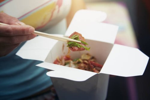 woman eating asian fast food from a cardboard box - junk food stock pictures, royalty-free photos & images