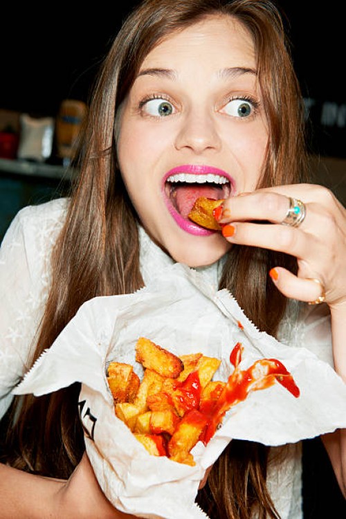 woman eating bag of ships - junk food stock pictures, royalty-free photos & images