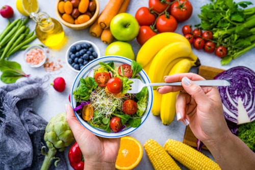 woman eating fresh rainbow colored salad. multicolored fruits and vegetables background. healthy eating and dieting concept - food stock pictures, royalty-free photos & images