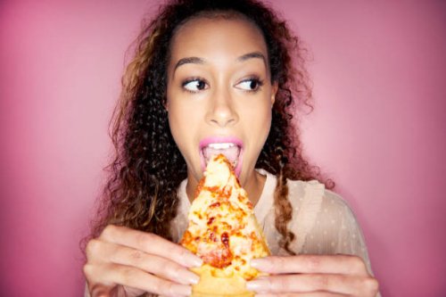 woman eating pizza slice - junk food stock pictures, royalty-free photos & images