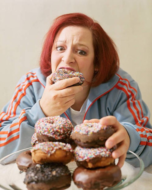 woman eating stacks of donuts - junk food stock pictures, royalty-free photos & images