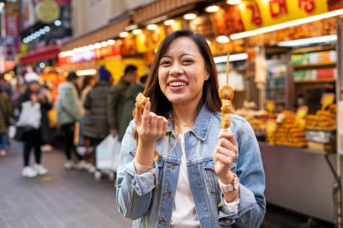 woman eating street food at market - food photos et images de collection