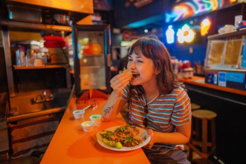 woman eating taco in a bar - food stock pictures, royalty-free photos & images