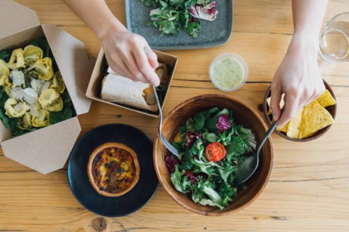 woman eating takeaway vegetarian food at home - junk food stock pictures, royalty-free photos & images