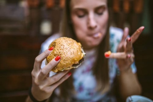 woman enjoying delicious burger - junk food stock pictures, royalty-free photos & images