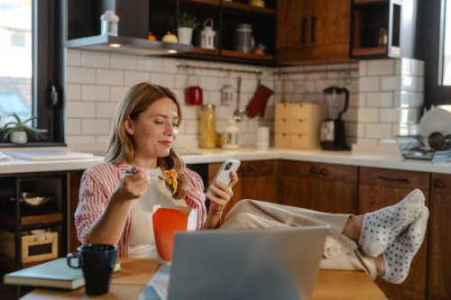 woman enjoying food home delivery and using smart phone - junk food stock pictures, royalty-free photos & images